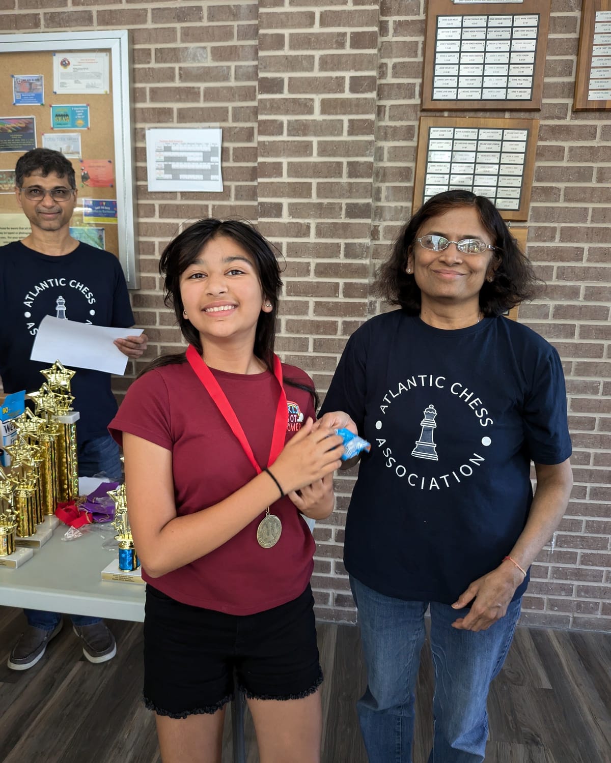 Viti smiling with her medal next to a tournament organizer