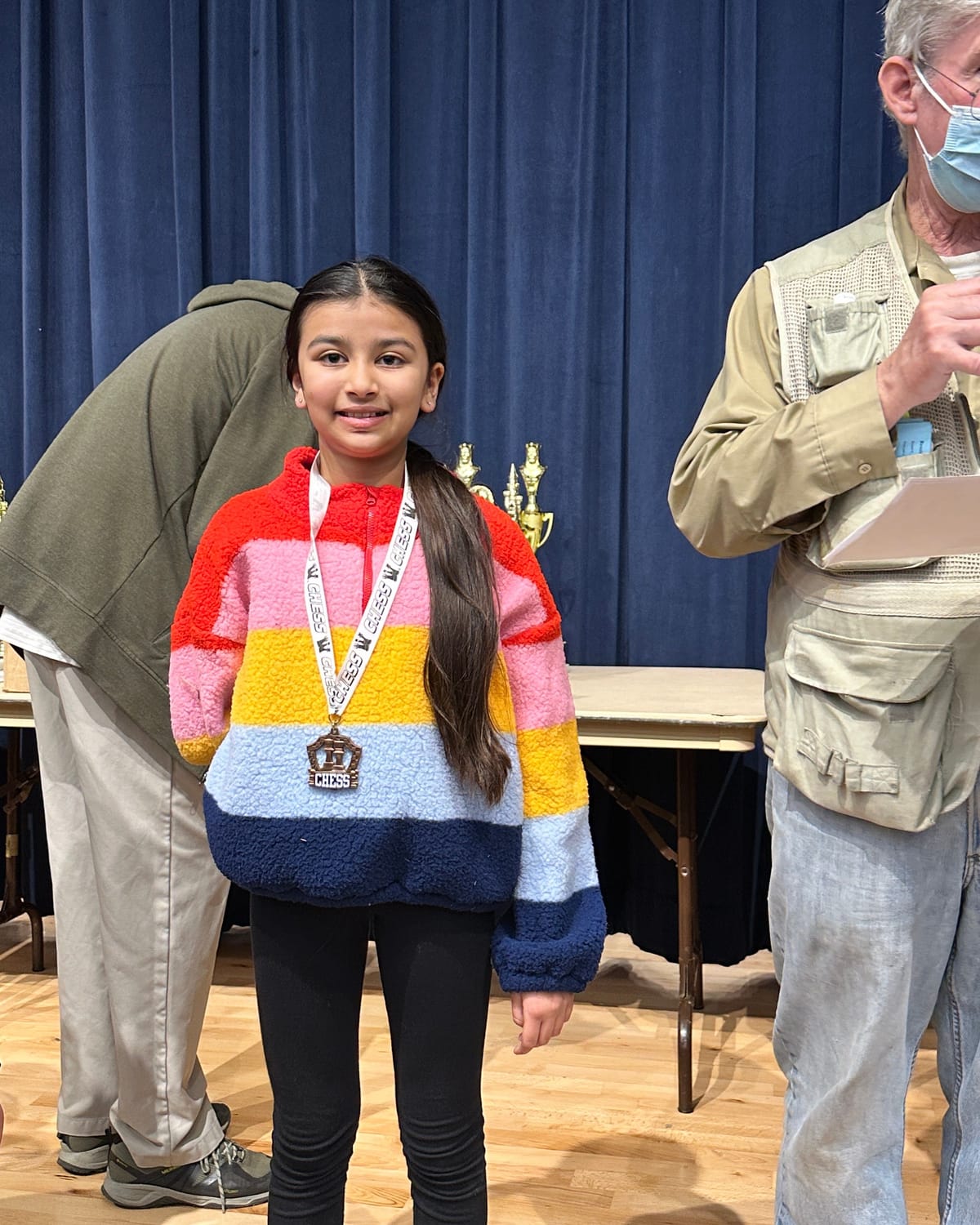 Viti smiling with her 3rd place chess medal at the awards ceremony