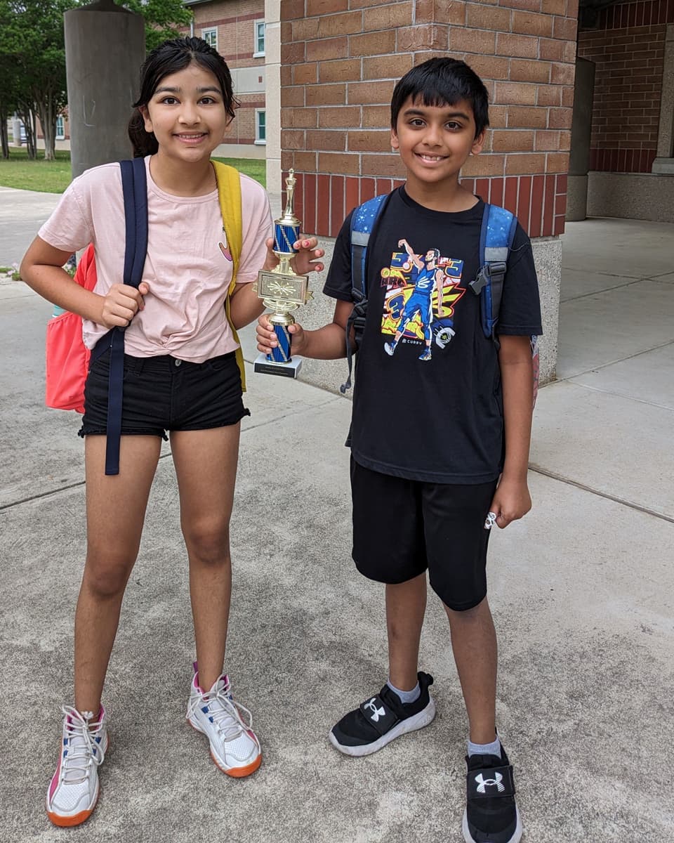 Viti and a teammate smiling with their 1st place team trophy