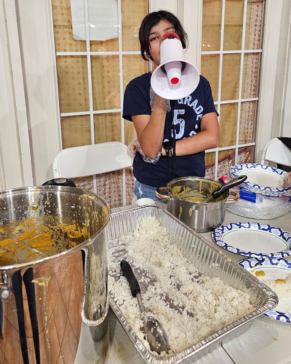 Viti calling out through a megaphone at the food serving table